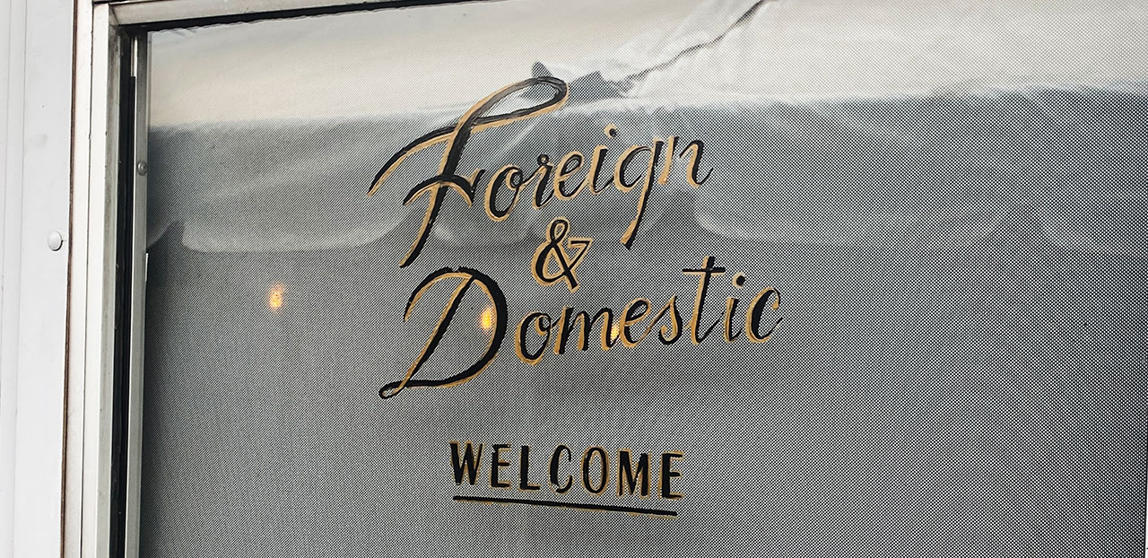 Foreign and Domestic restaurant welcome sign on front door in Austin, Texas.