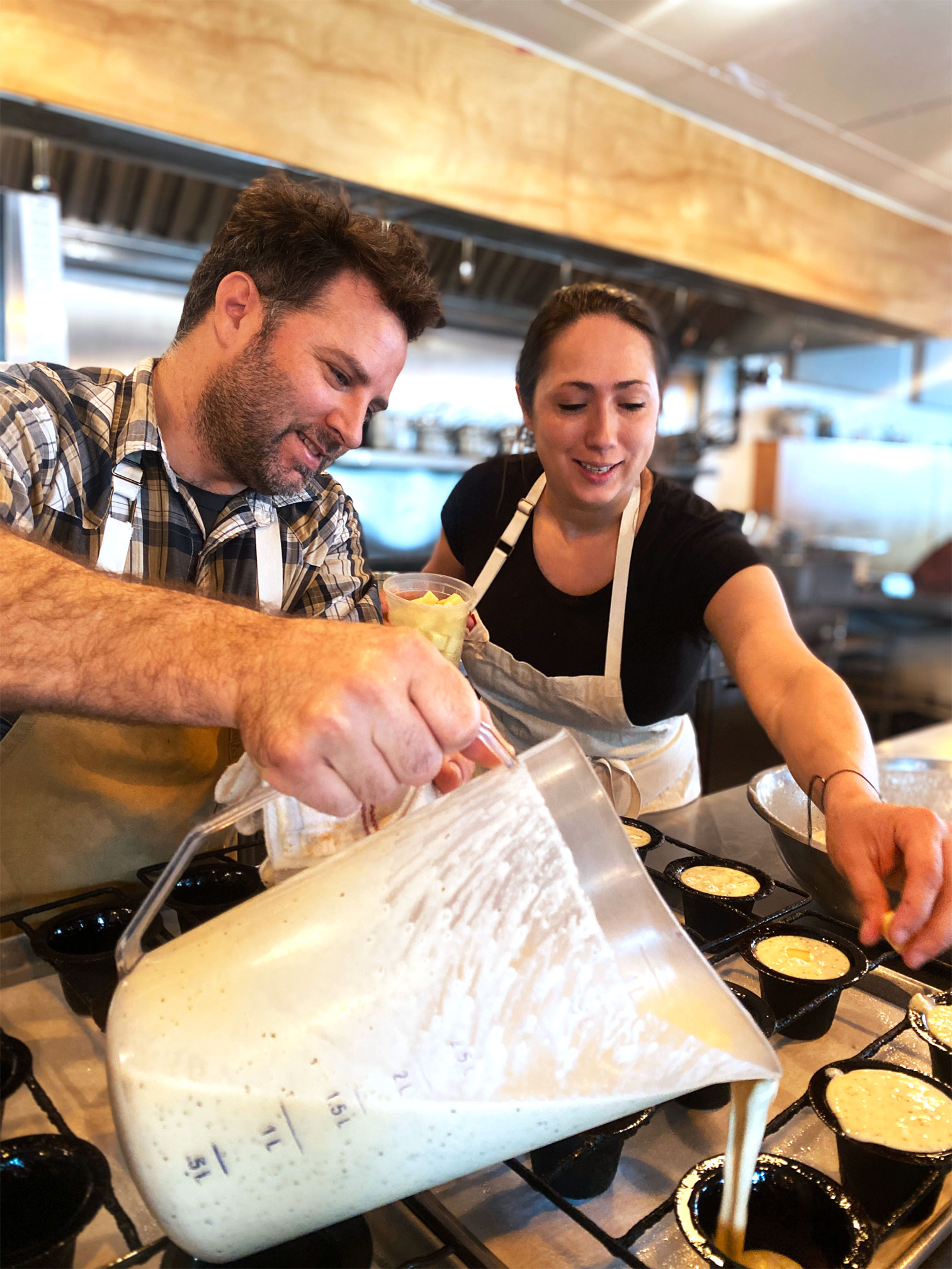 Chef/Owners Sarah Heard and Nathan Lemley pour batter together in Foreign and Domestic.